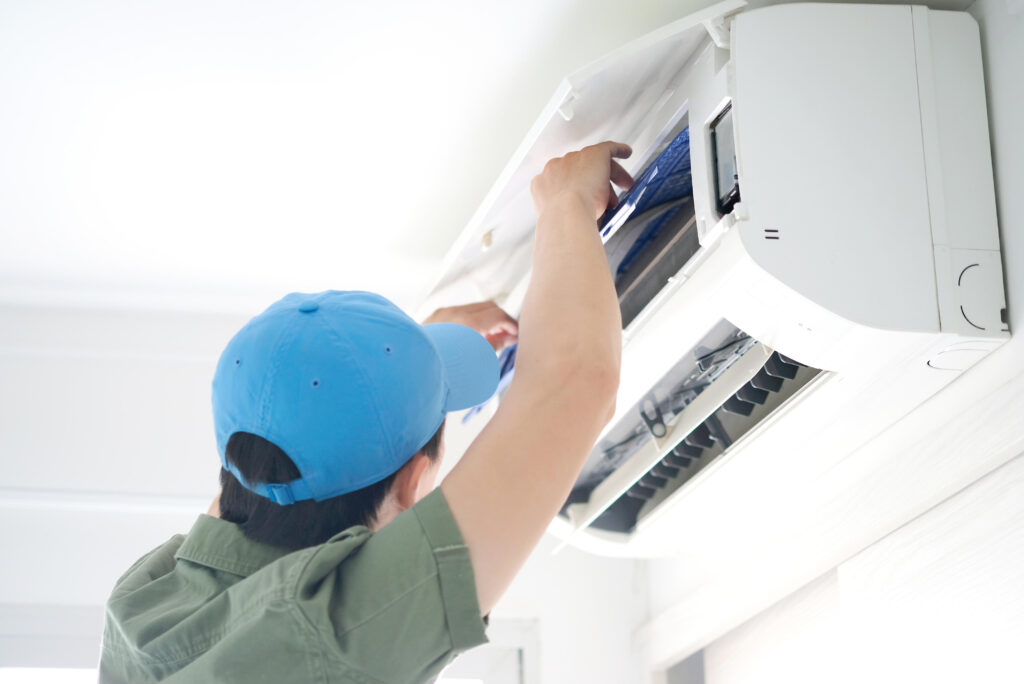 Techniker repariert eine defekte Klimaanlage in einem Wohnraum